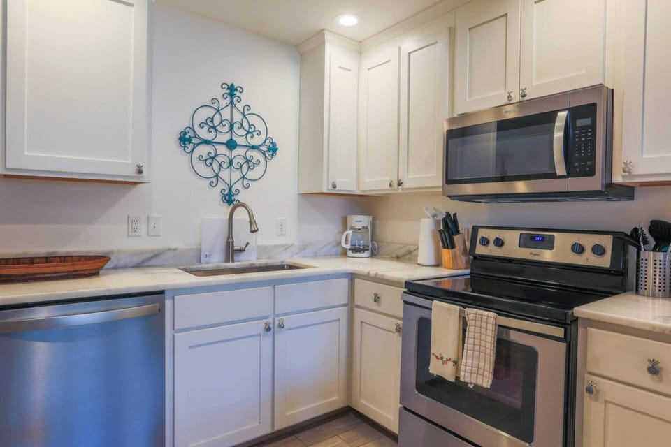 This home has a renovated kitchen with white cabinets and stainless steel appliances.