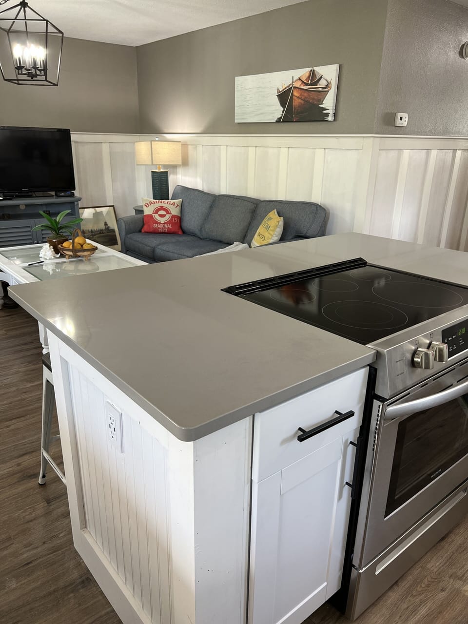 glass top stove on island facing seating/ tv area for everyone to socialize 