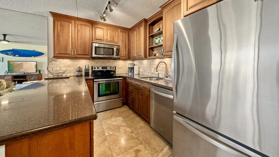 Cherry wood cabinets and fully stocked kitchen.