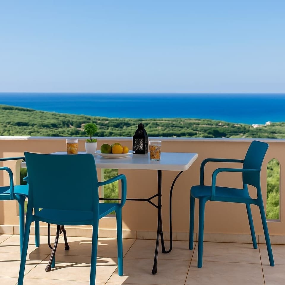 Balcony Dining with Sea and Pool Views – Outdoor dining table on the balcony with direct views of the sea and the shared pool between two properties.