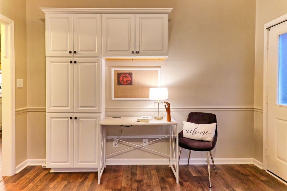 Desk in den with spare mousepad, outlets & bulletin board to post plans & notes.