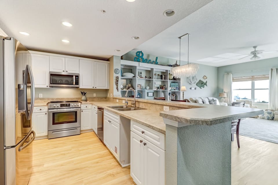 Fully Equipped Kitchen with Stainless Steel Appliances and Bar Stool Seating for 4