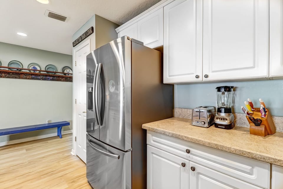 Fully Equipped Kitchen with Stainless Steel Appliances and Bar Stool Seating for 4