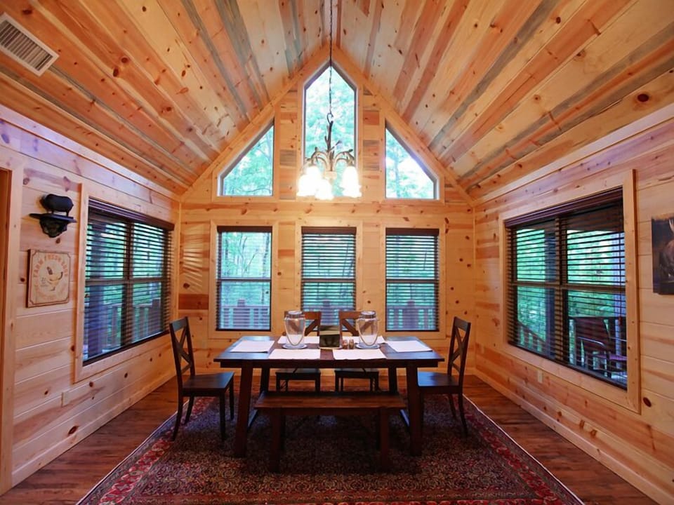 Share meals beneath stunning windows in this cozy cabin space
