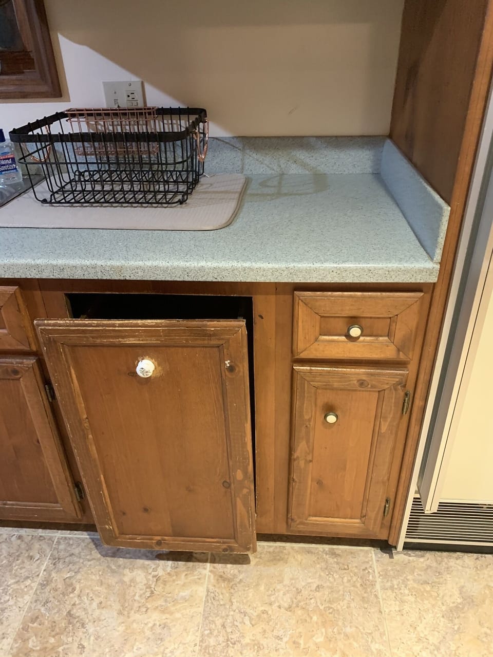 Trash can located in this drawer beneath dish drain.
