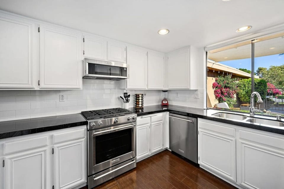 A bright, modern kitchen with sleek appliances and a stunning view—perfect for cooking and gathering!