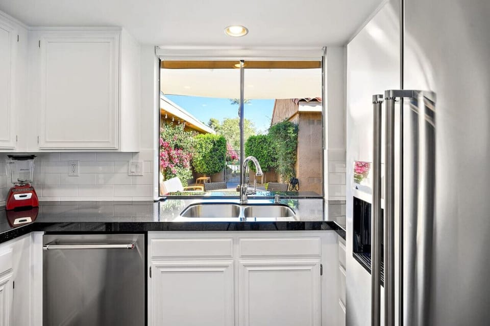 Enjoy washing dishes with a view! This bright kitchen window opens to a lush outdoor oasis, making every moment feel refreshing.