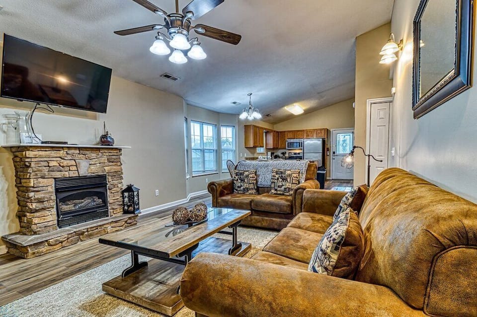 Living Room: Inviting space with plush sofas, stone fireplace, and light-filled windows for relaxation.