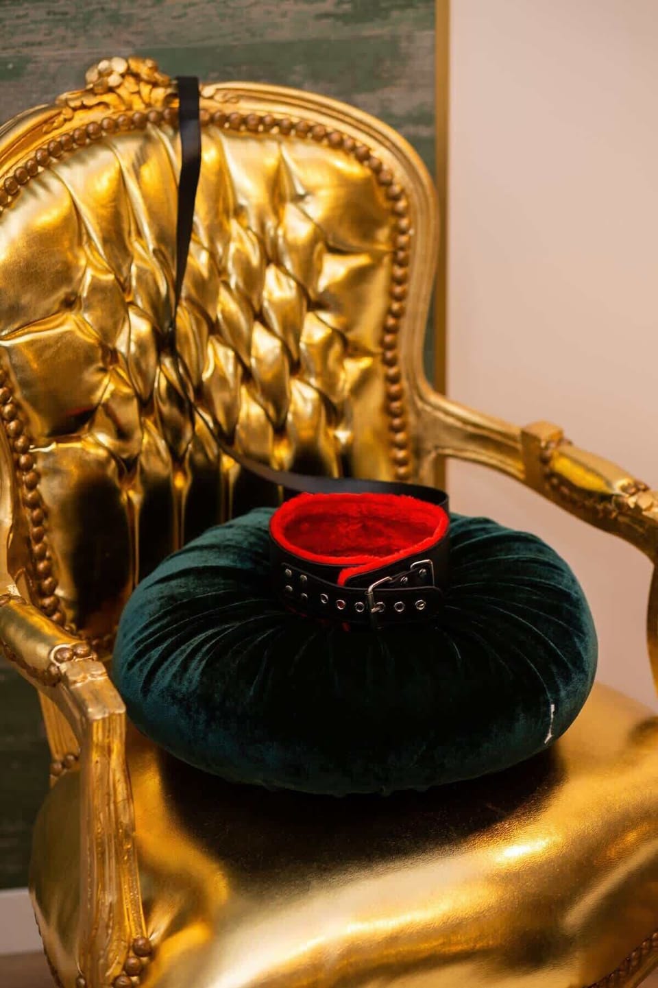 A golden vintage-style chair adorned with a red heart-shaped pillow, creating a romantic vibe.