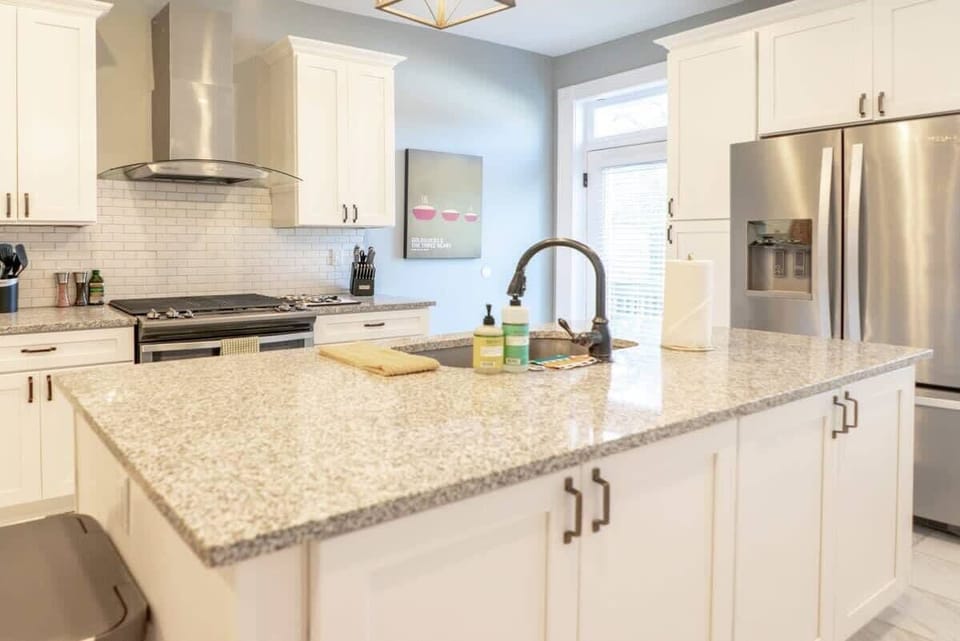 The kitchen features high-end stainless steel appliances and sleek granite benchtops