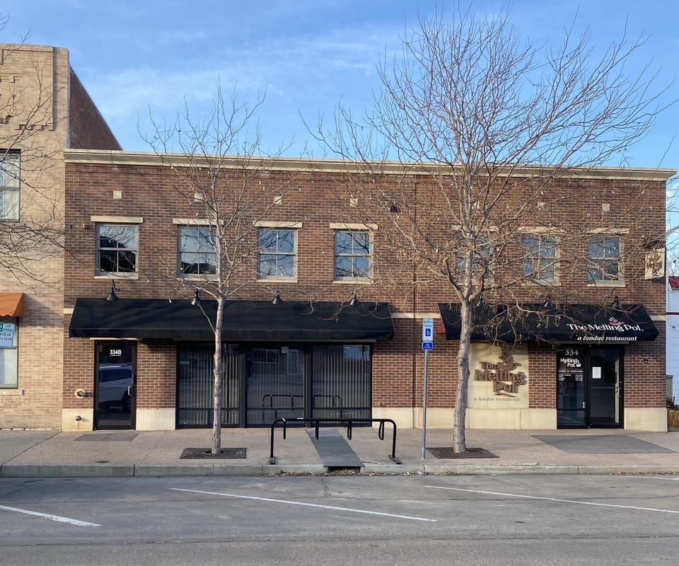 Front of building. Located one door West of The Melting Pot. 