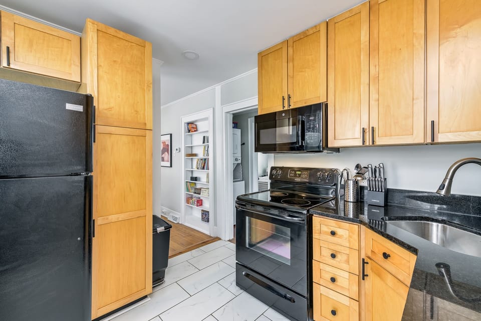 Fully equipped kitchen with electric stove,  and microwave.