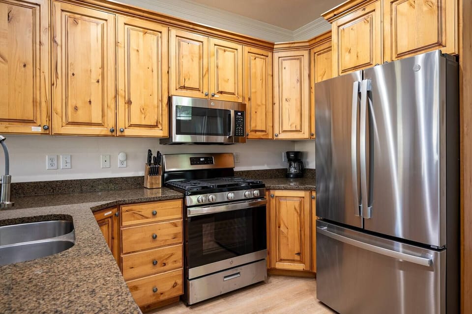 With its modern lighting, windows, and quartz countertops, the kitchen makes preparing dinner a truly enjoyable experience.
