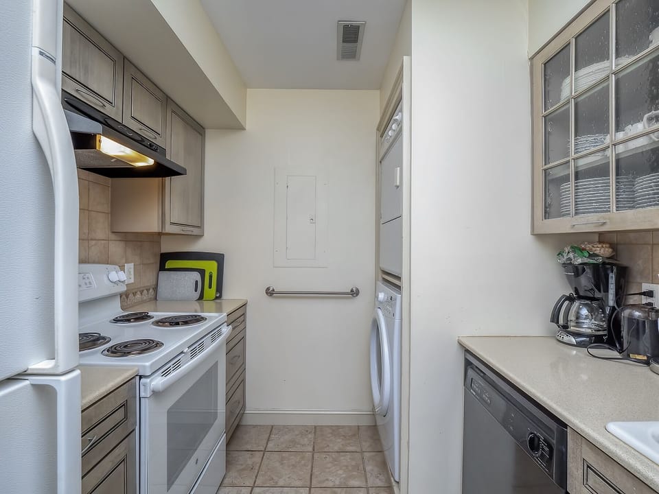 The stacked washer and dryer are just off the kitchen.