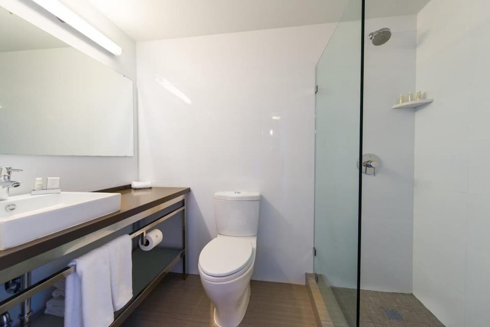 Refresh in a sleek bathroom with glass shower and bright vanity.