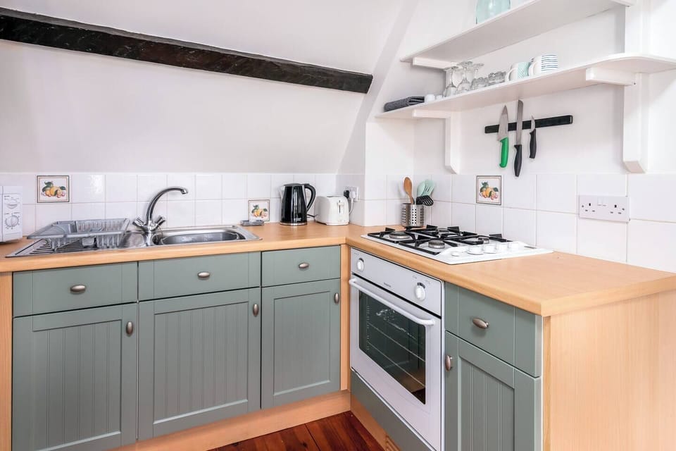 Kitchen that has oven, microwave, fridge, toaster, kettle, full set of kitchen ware, dining ware, glassware and cutlery.