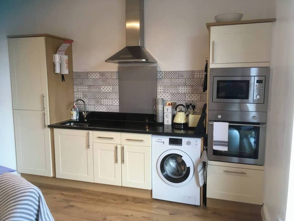 This is the Kitchen. It has an oven, electric hob, microwave, fridge and freezer, toaster, kettle, washer, full set of kitchen ware, dining ware.