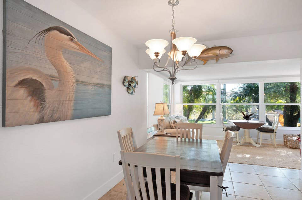 Gather around your dining table beneath coastal artwork and warm lighting, with tropical views framing your meals.