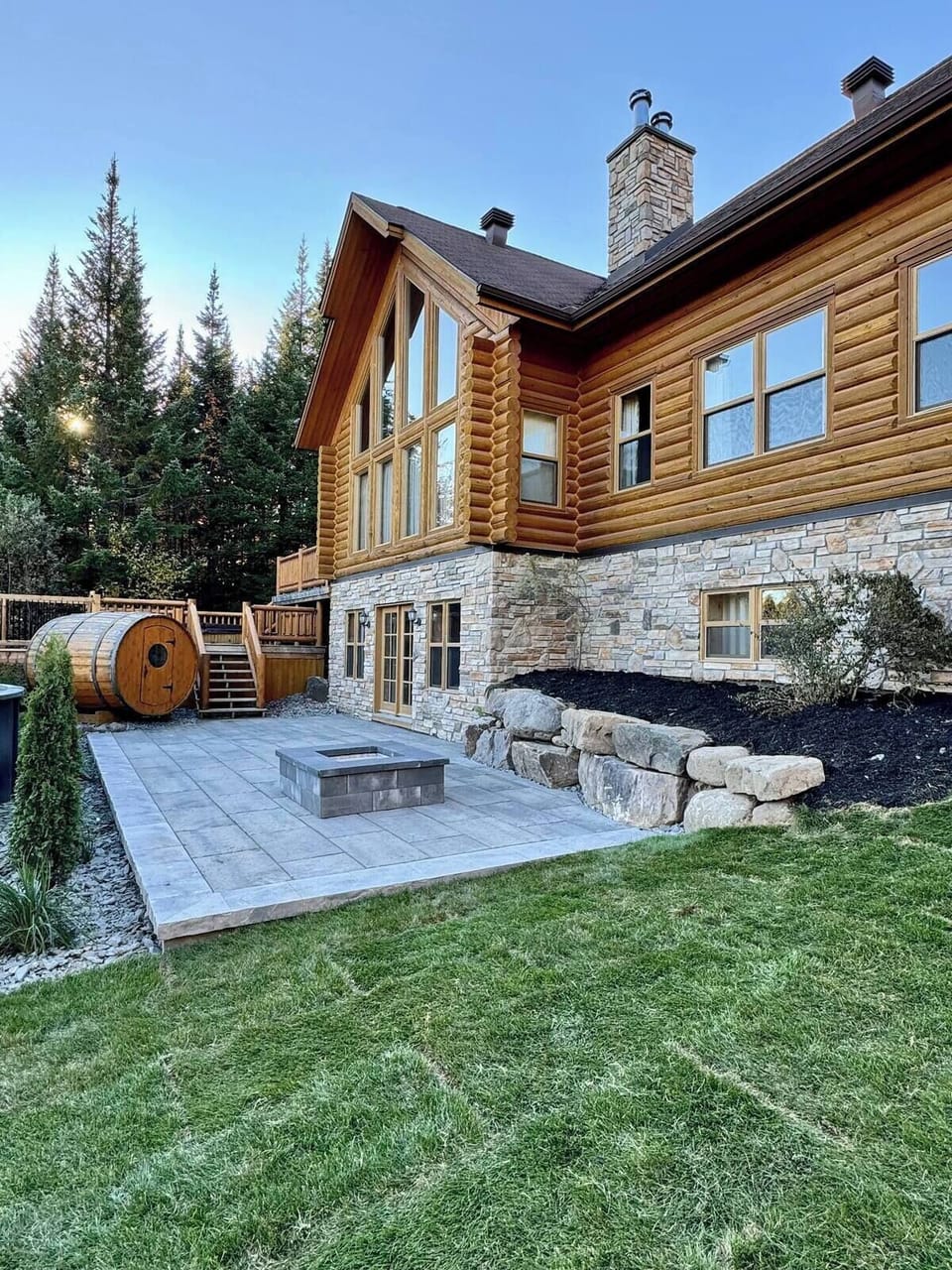 Outdoor view of the home with pool, fire pit, and surrounding forest