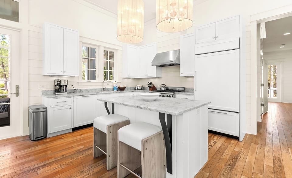 You'll love preparing meals in this bright, modern kitchen with marble countertops and elegant pendant lighting.