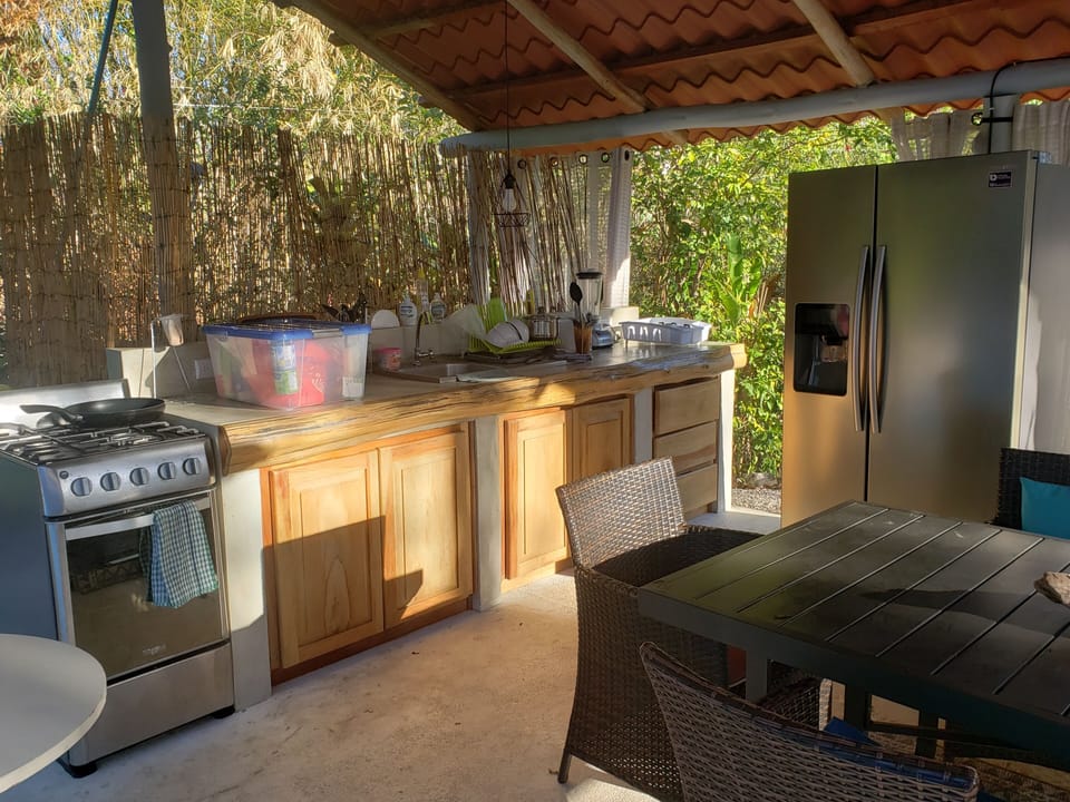 large outdoor kitchen and dining area, poolside