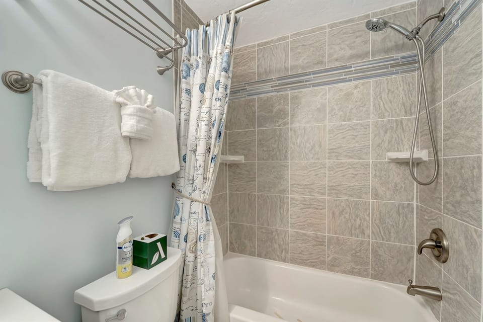 Freshen up in the bright, modern bathroom at Siesta Beach House #314. A renovated and tastefully decorated shower, spacious vanity, and fresh towels add comfort to this 2-bedroom Siesta Key vacation rental near Crescent Beach, private gated beach access.
