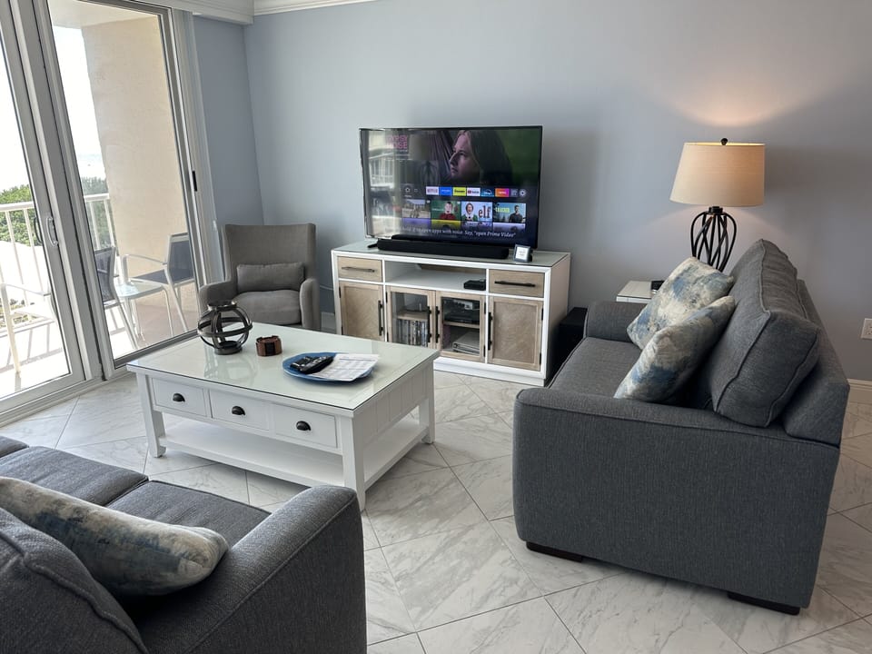 Living room with queen sleeper sofa, 55" TV, loveseat, chair & coastal furniture