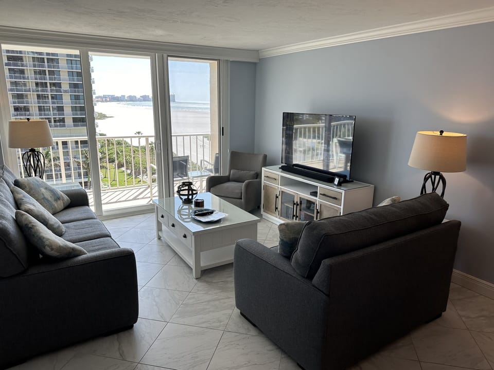 Living room with queen sleeper sofa, 55" TV, loveseat, chair & coastal furniture