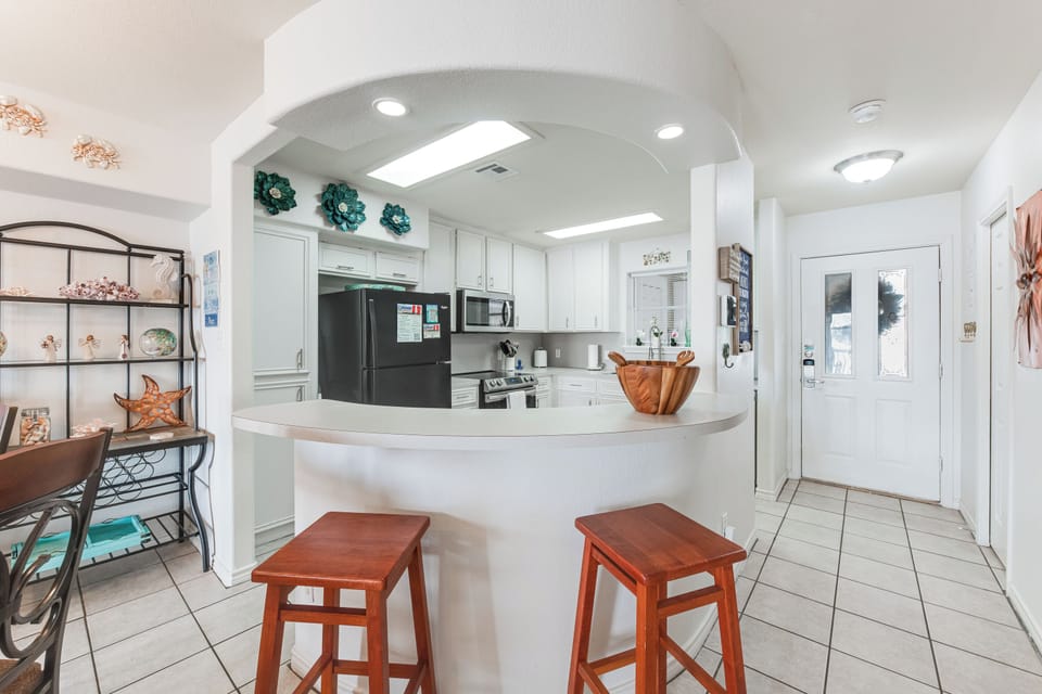 Gather around your bright, fully-equipped kitchen with curved counter seating and modern appliances for memorable meal prep together.