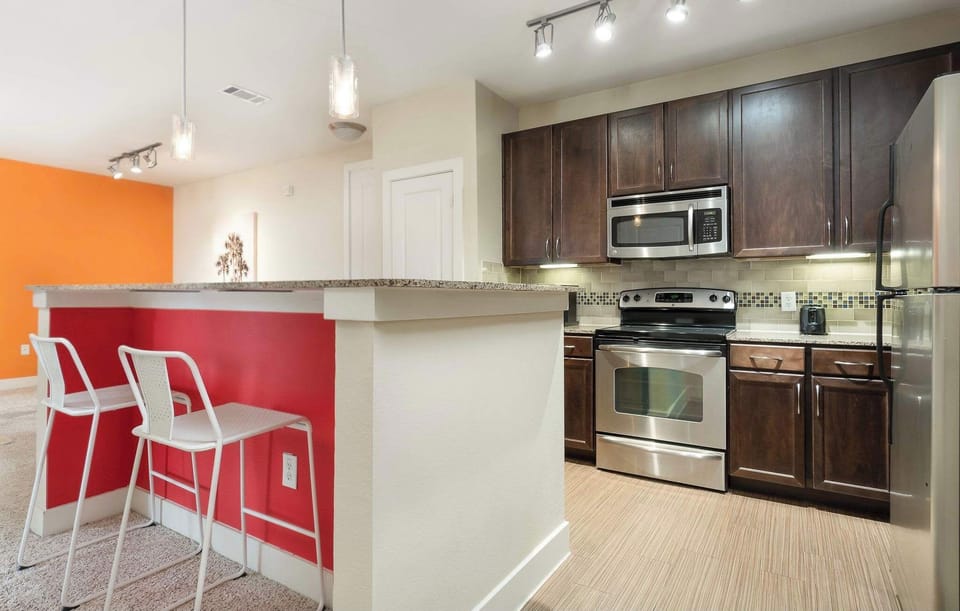Large kitchen with island/bar, fully stocked with kitchen supplies; perfect for long-term stays