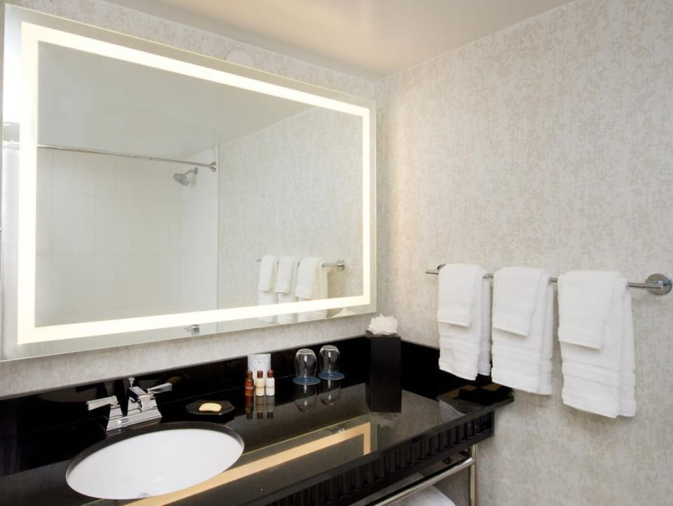 Refresh effortlessly at the sleek vanity with glowing mirror.