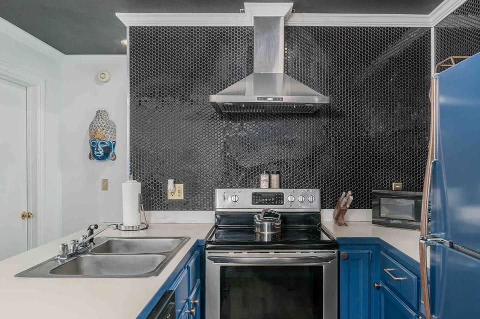 Fully tiled backsplash behind an induction cooktop and full oven.