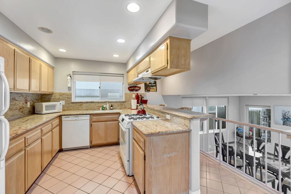 Bright kitchen w/ wood cabinetry, granite counters & full-size appliances