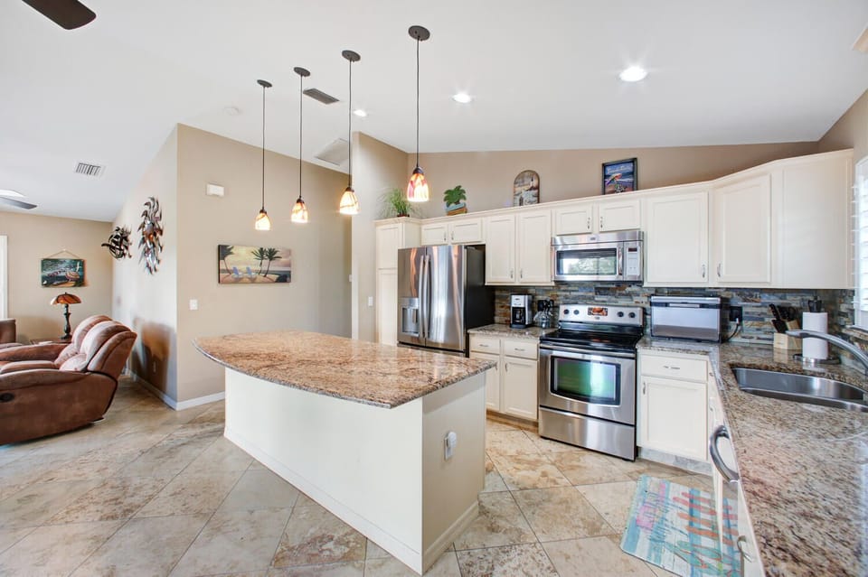 Open-concept kitchen with granite countertops, stainless steel appliances and fully equipped with cooking utensils. Island has two seats which are not shown in photos.