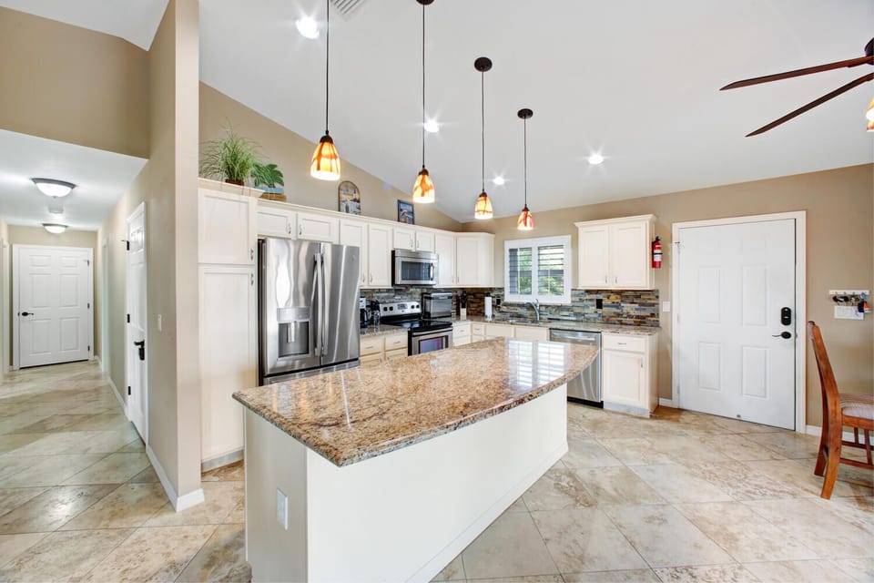Open-concept kitchen with granite countertops, stainless steel appliances and fully equipped with cooking utensils. Island has two seats which are not shown in photos.