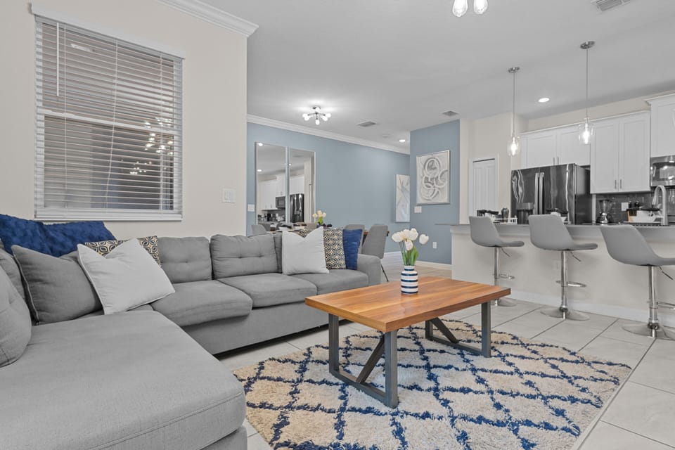 Unwind on your plush sectional sofa in this bright, open living space where comfort meets modern elegance and fresh flowers welcome you home.