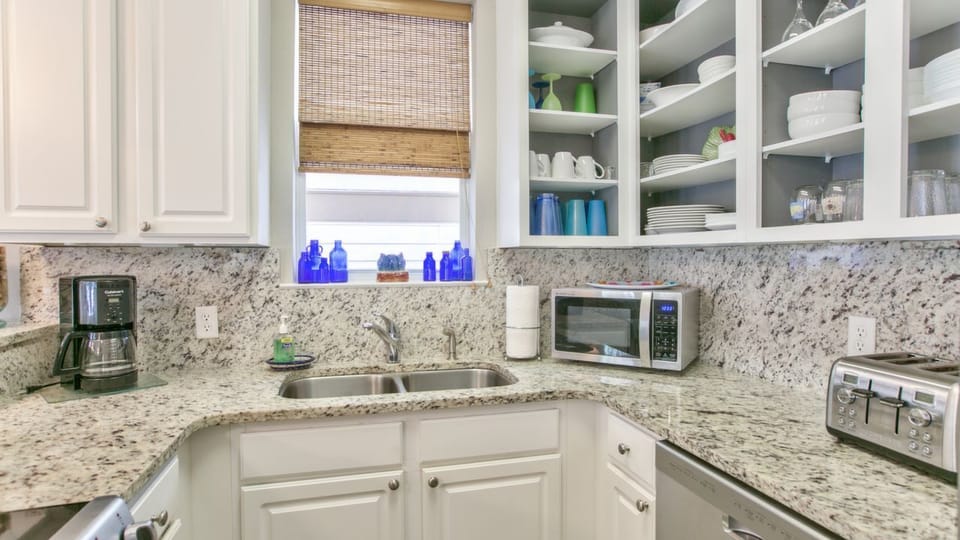 The kitchen has a microwave, coffee maker, dishwasher, and plenty of storage. 
