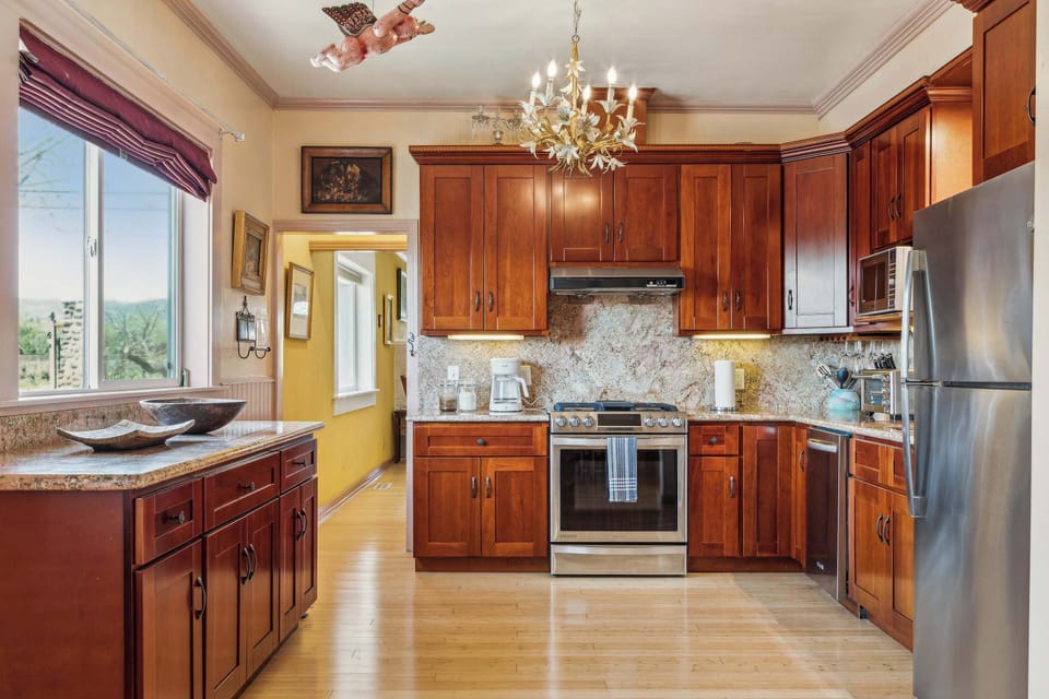Warm, classic kitchen with rich wood cabinets, granite counters, and plenty of space—perfect for cooking and enjoying meals together.

