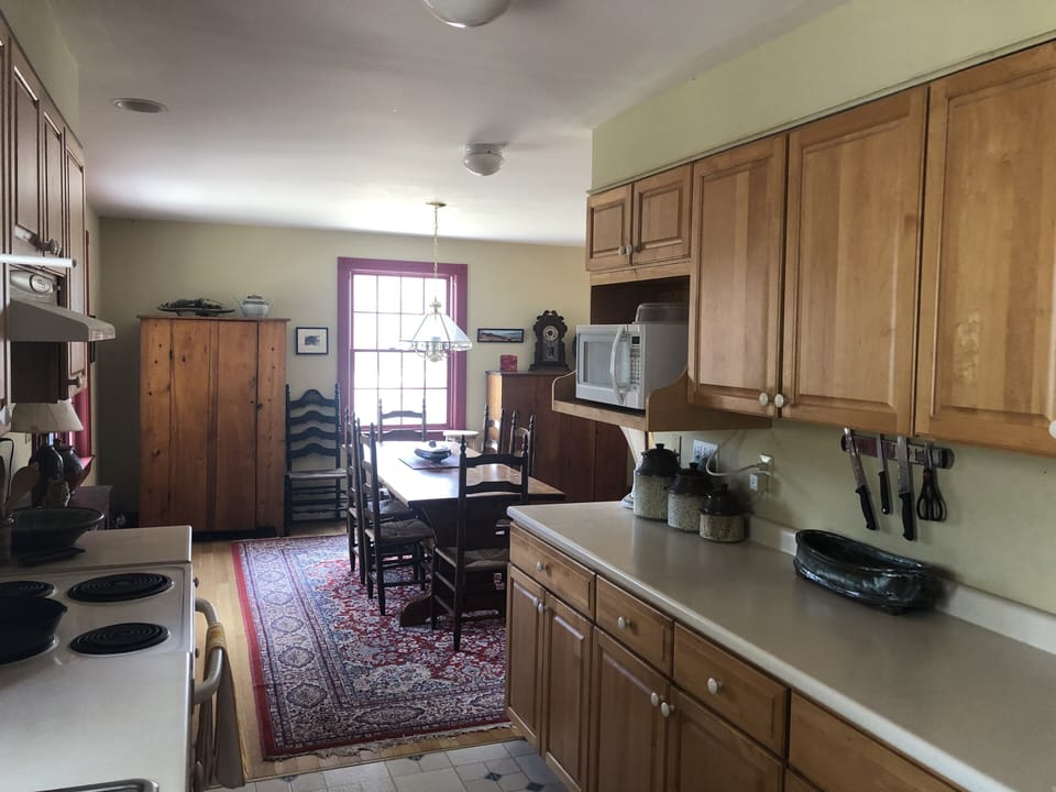 Galley kitchen with electric range, microwave, well-equipped for cooking. 