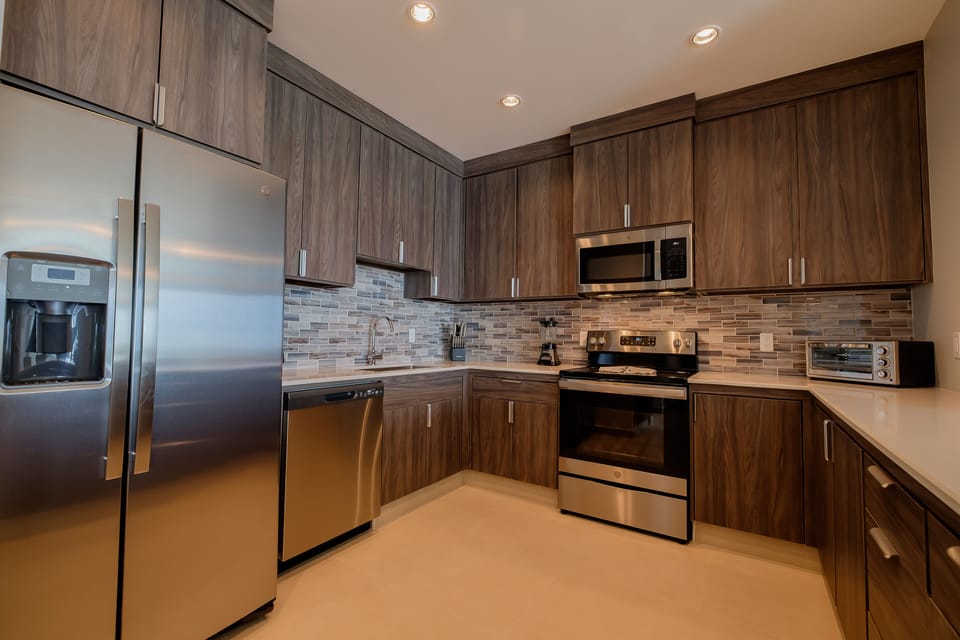 Kitchen with oven, stove top, toaster, microwave, blender and dishwasher.