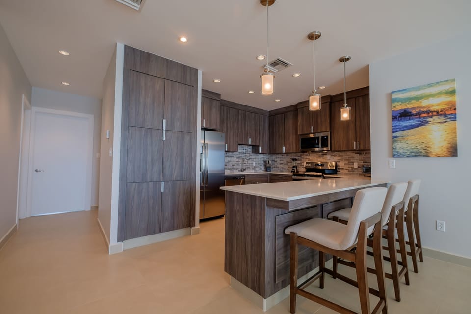 Full kitchen with utensils, pots, pans, plates, bowls and silverware.