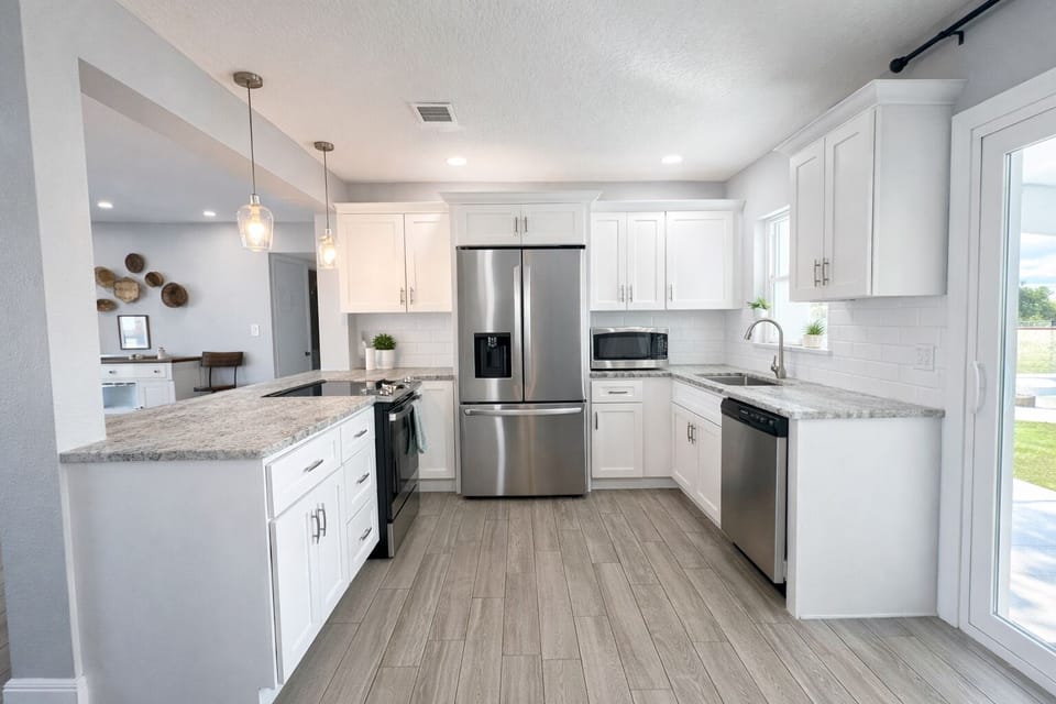 Beautifully remodeled kitchen with stainless steel appliances. Sliders to patio