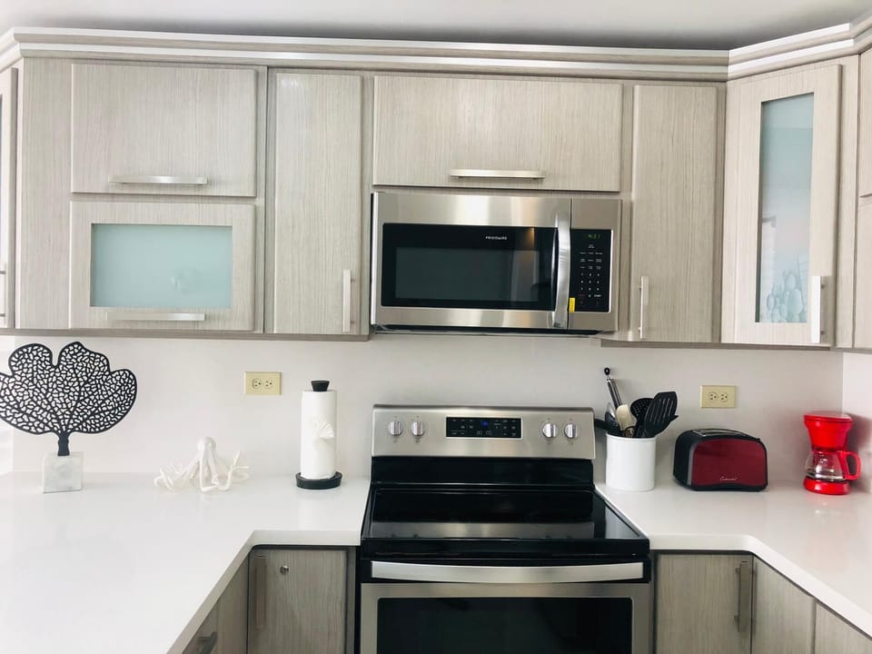 Stylish kitchen furniture with white countertops and modern appliances.