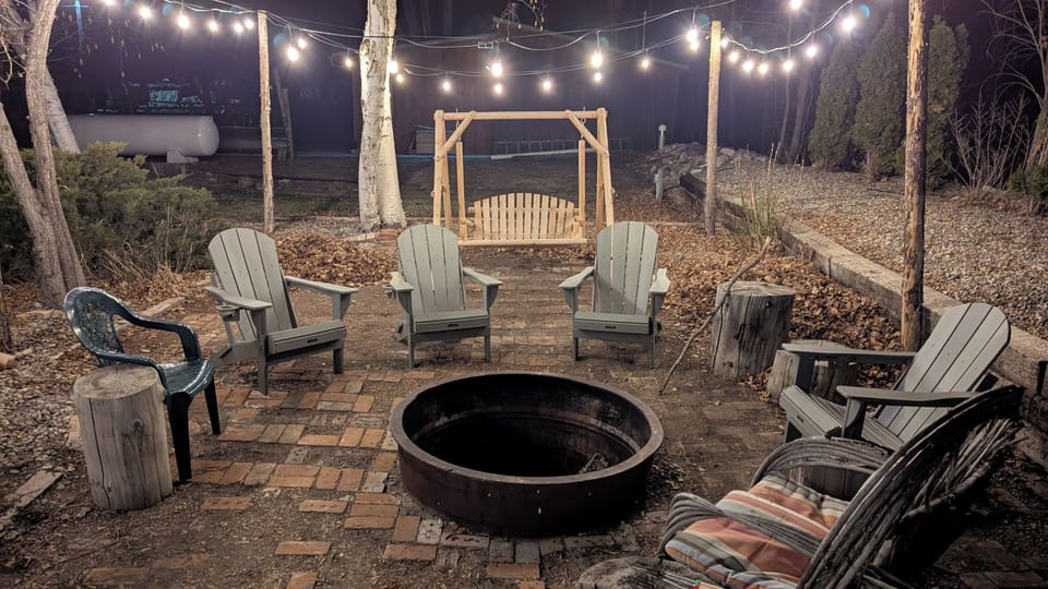 Backyard patio and fire pit. Adirondack chairs and swing chair.