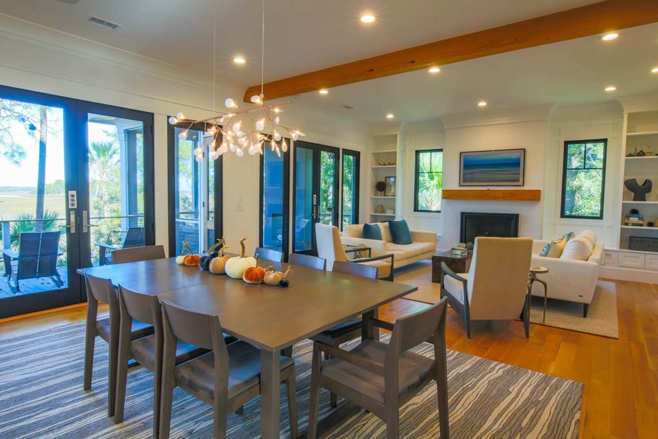 The marsh side of the first floor features a nearly full wall of windows & glass doors.