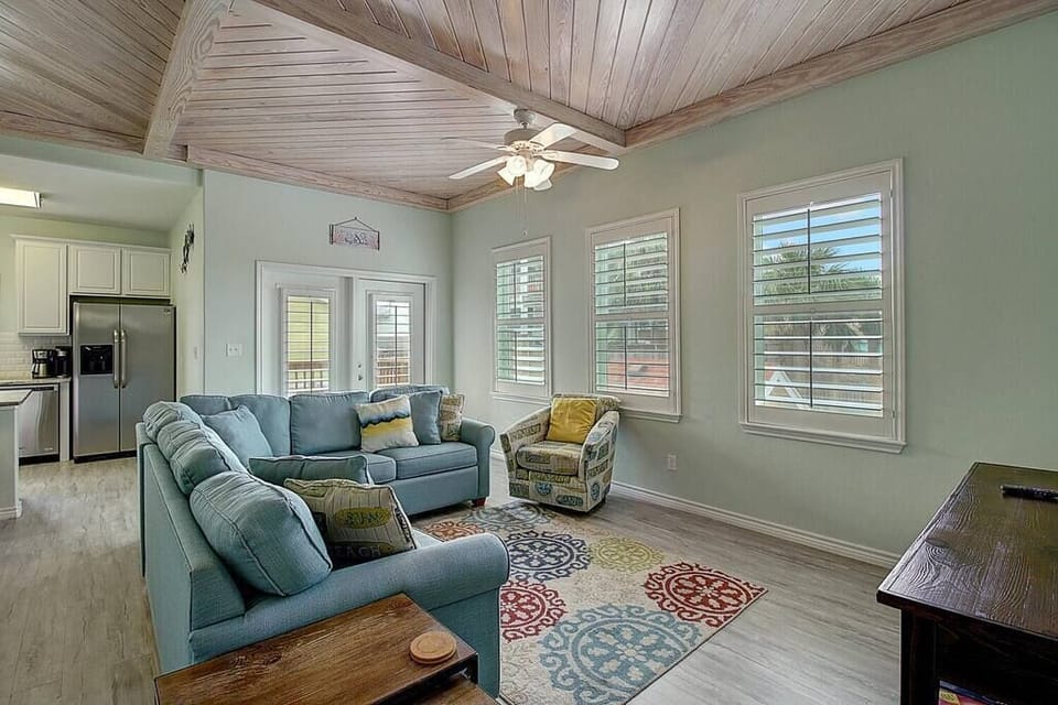 The living room features a comfortable sectional couch, complemented by additional chairs for ample seating options and ultimate relaxation