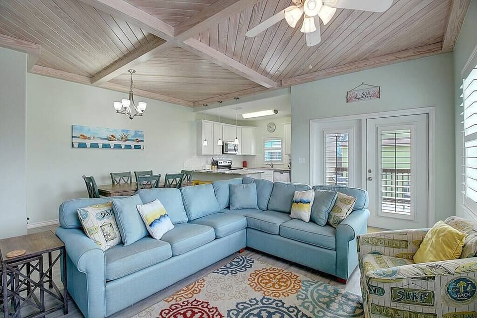 The living room features a comfortable sectional couch, complemented by additional chairs for ample seating options and ultimate relaxation