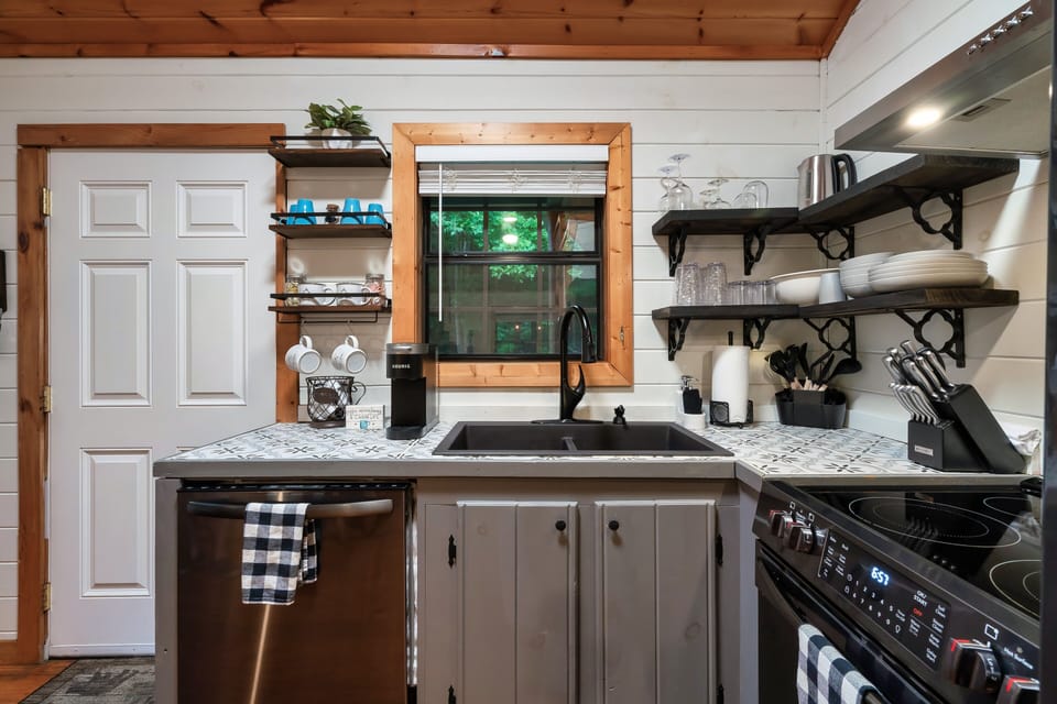 Charming cabin kitchen—modern appliances, open shelves, and coffee nook.
