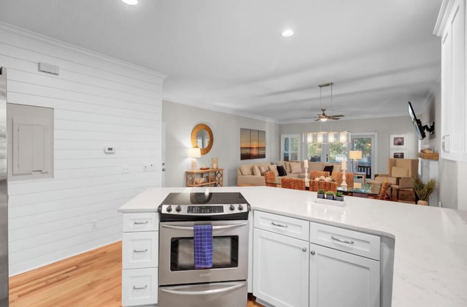 Cook with ease in this bright, modern kitchen featuring sleek appliances and marble countertops, perfectly positioned to stay connected with your group.
