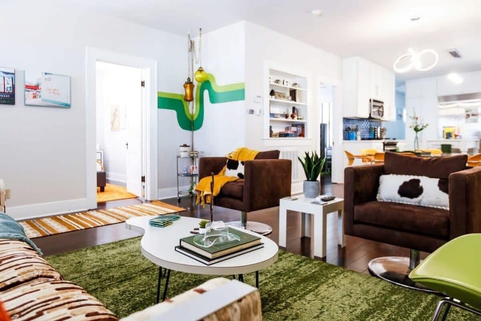 From the living room, you can see the groovy corner with 2 vintage swag lamps over a bar cart with vintage TX barware.